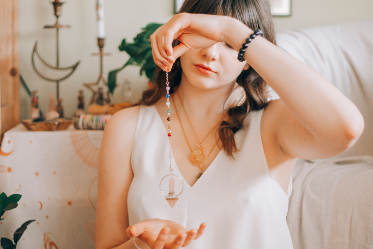 Woman telling fortune with silver pendant