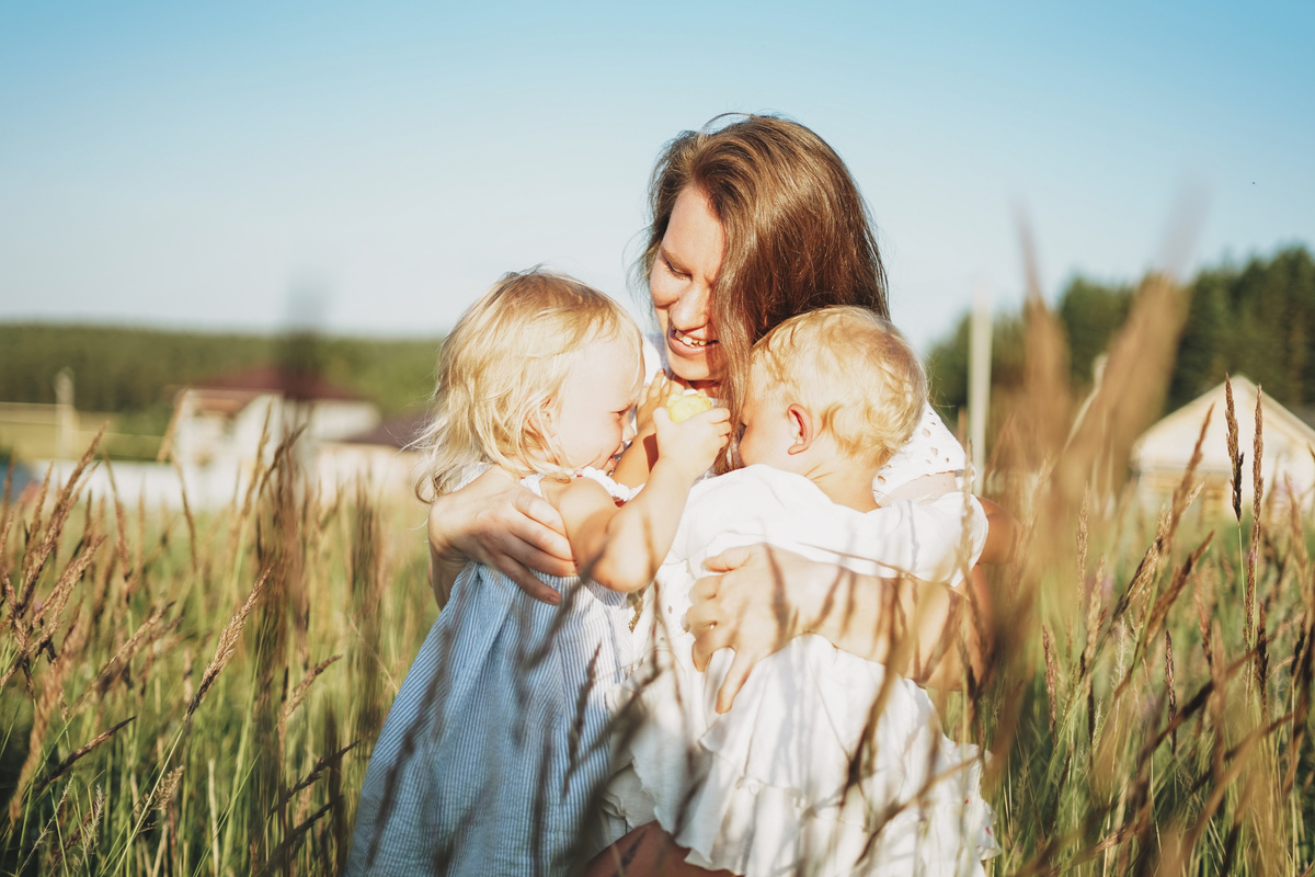 Mom Hugging Baby Girl Twins in the Backyard