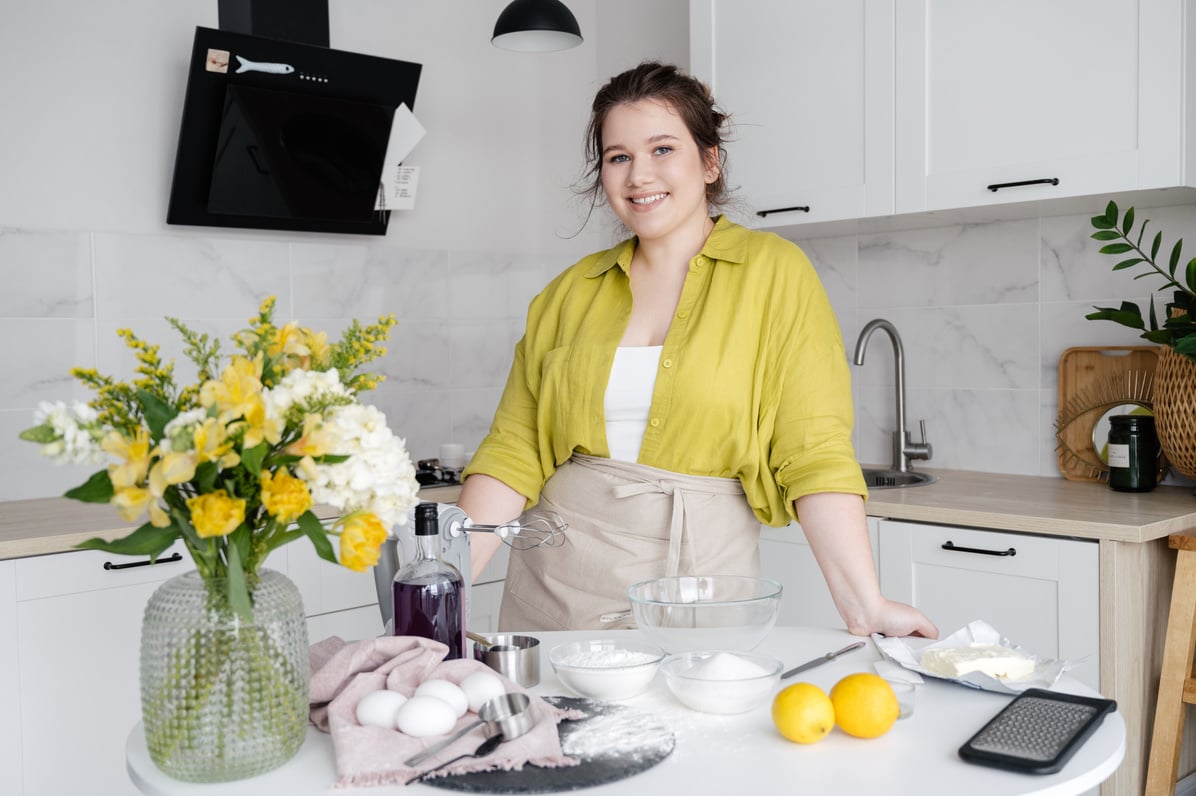 Smiling Homemaker with Cooking Ingredients on Table